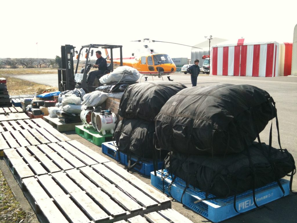 ヘリコプターで命を救う_ARROWSパイロットのリアルストーリー【#2】 5 支援物資をヘリコプターに載せる作業の写真